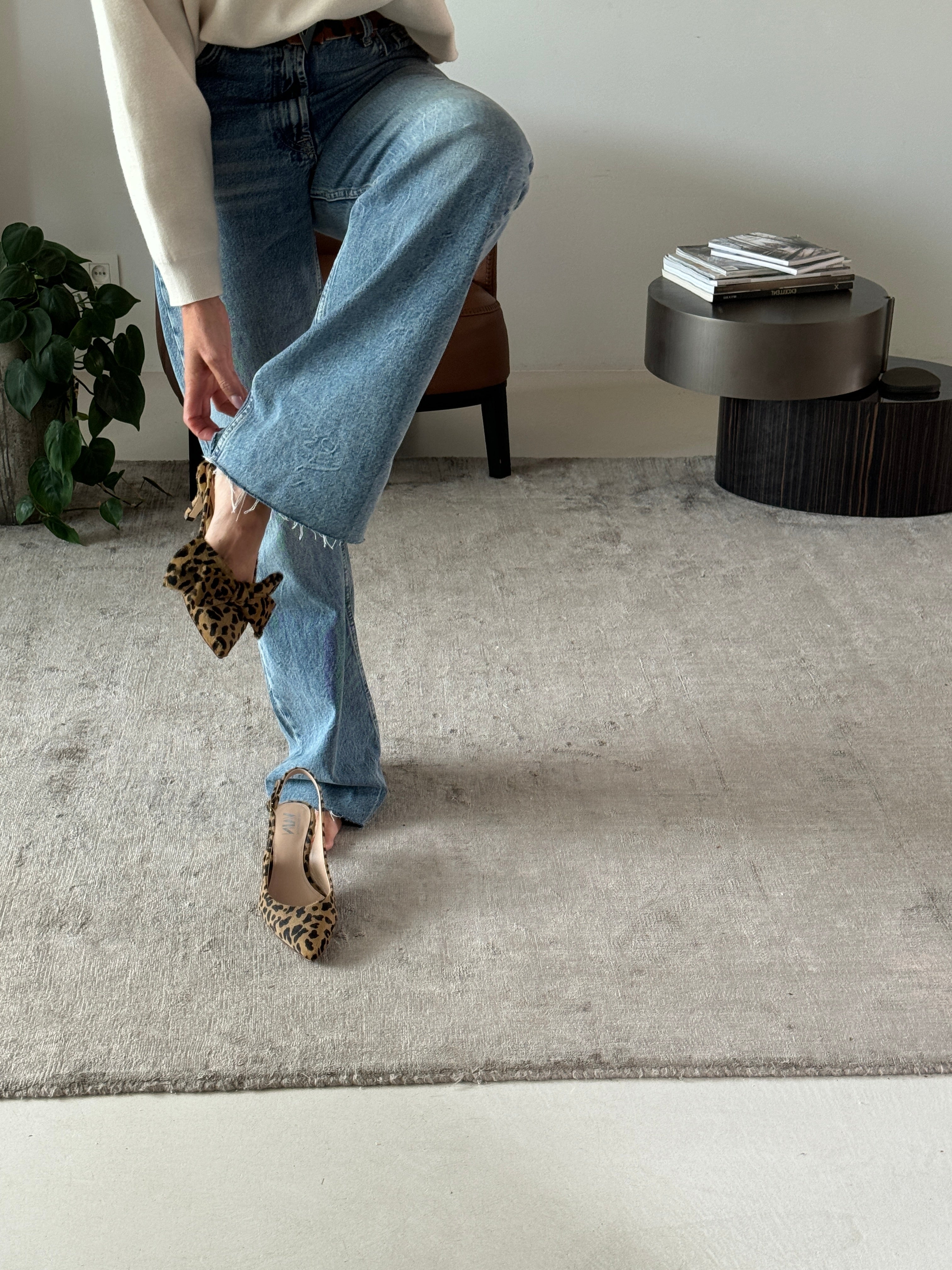 woman fitting on slingback kitten heels one with bow and one without bow