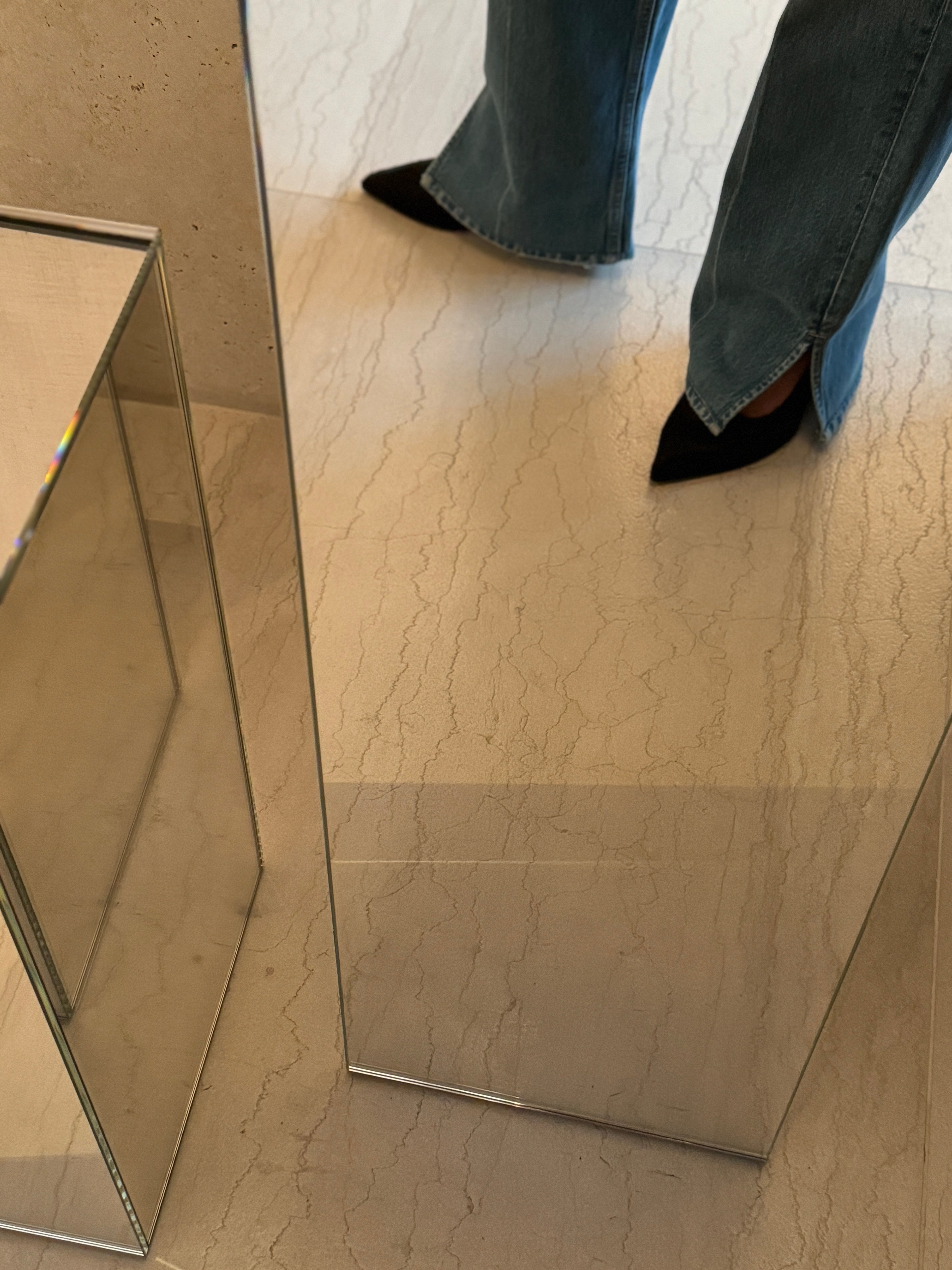 woman wearing brown pony heels and jeans looking in mirror