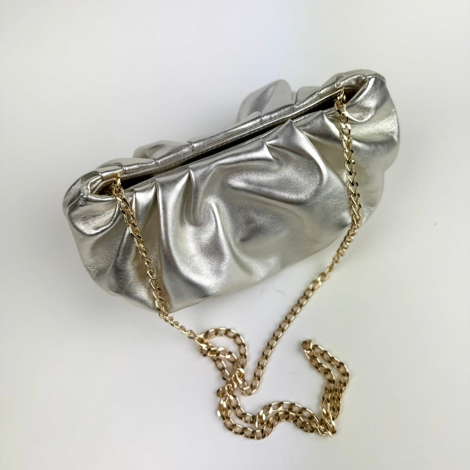 Champagne clutch bag with a chain on a white background