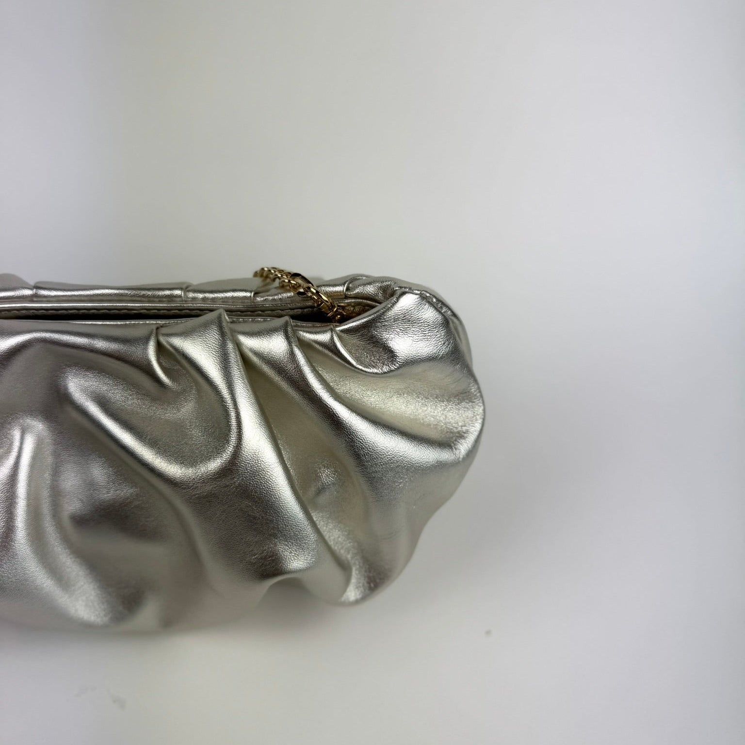 Champagne metallic clutch bag on a white background