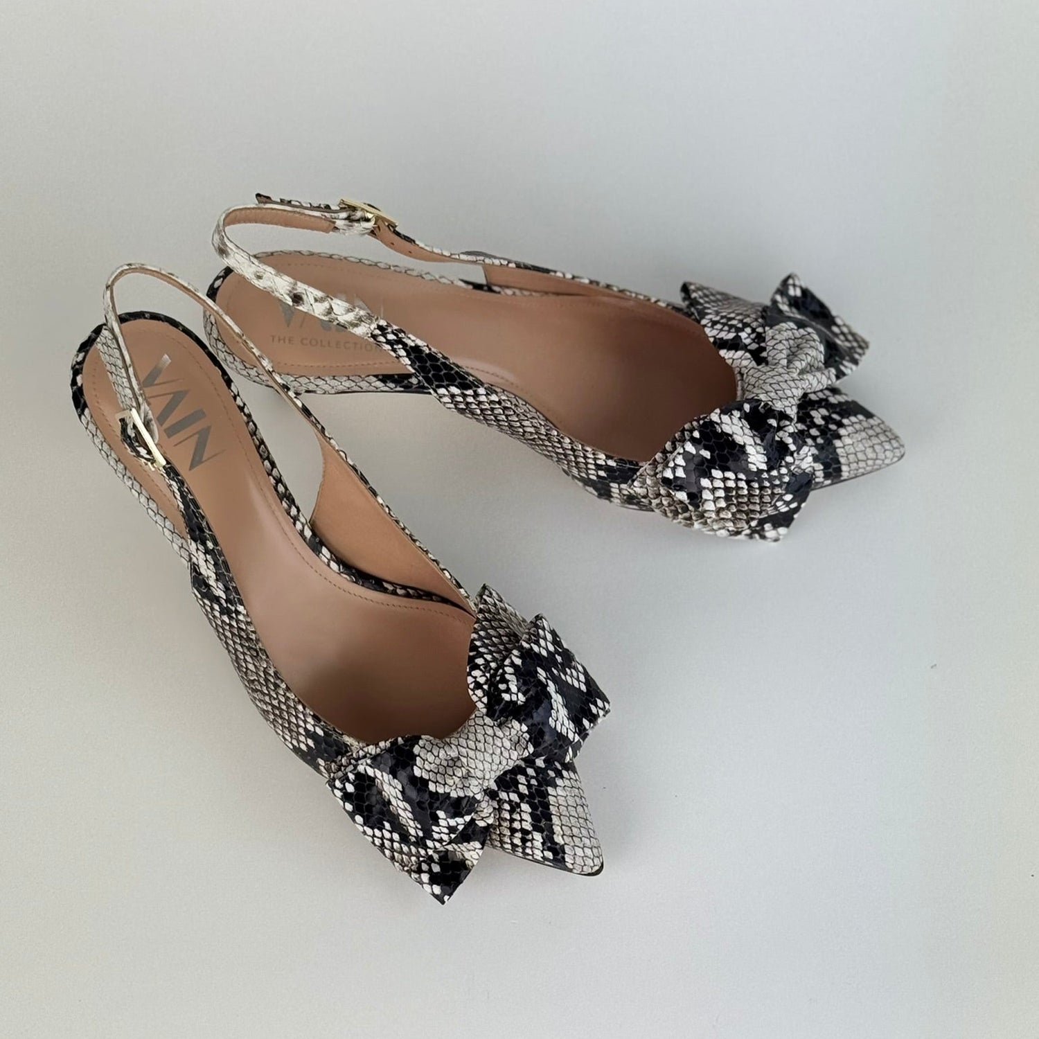 Pair of python printed kitten heeled sling backs on a light gray background