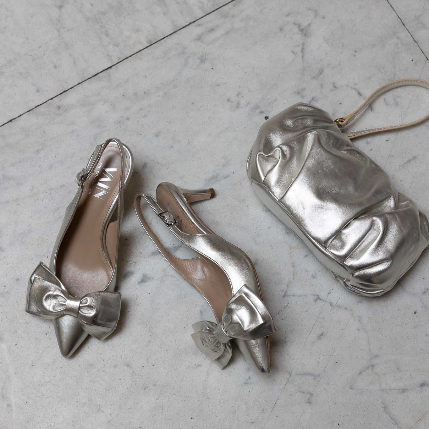 champagne coloured clutch and kitten heels on marble floor