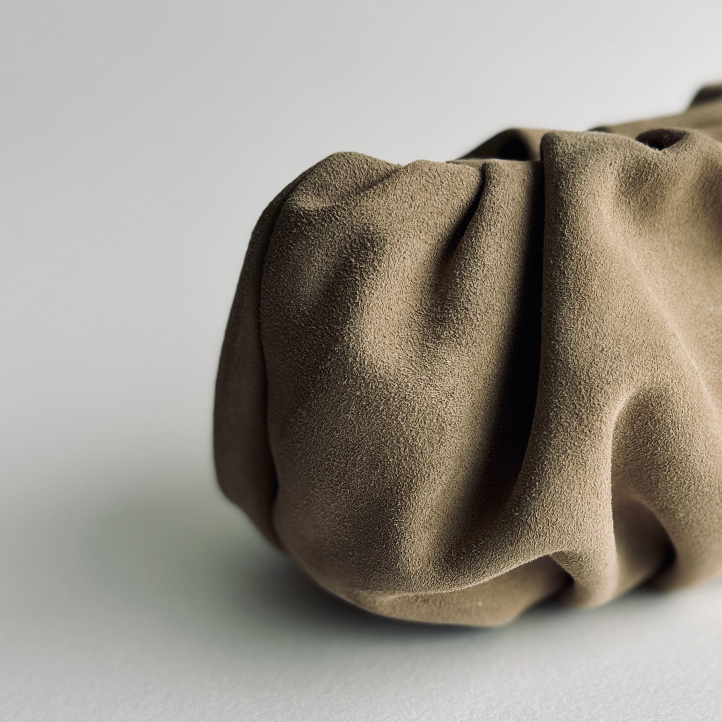 detail of curves of Jacky Clutch in sandbeige suede