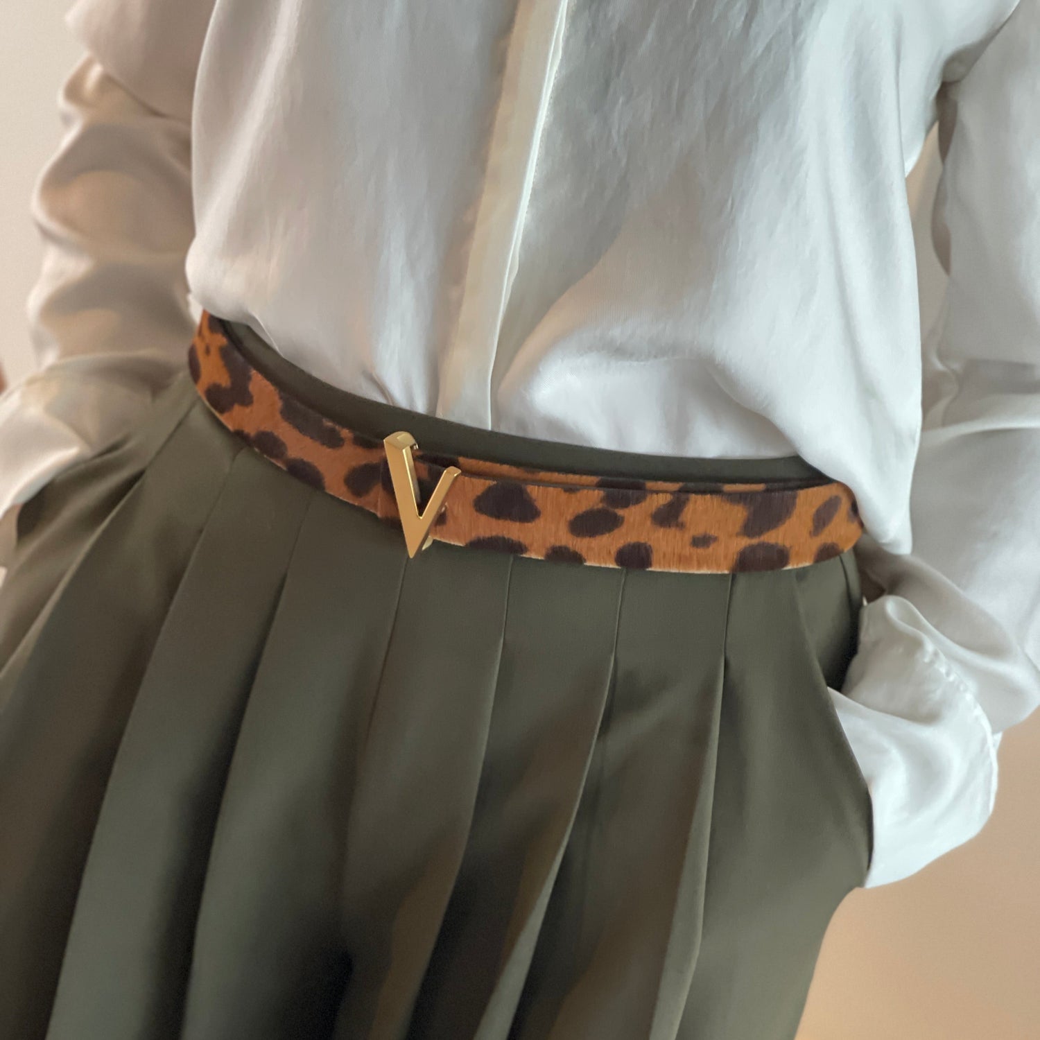 close up of woman wearing leopard printed leather belt with gold brushed buckle
