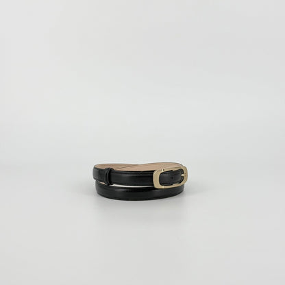 Black leather belt with a polished gold-tone metal buckle, showing the inner tan lining, set against a plain light gray background.
