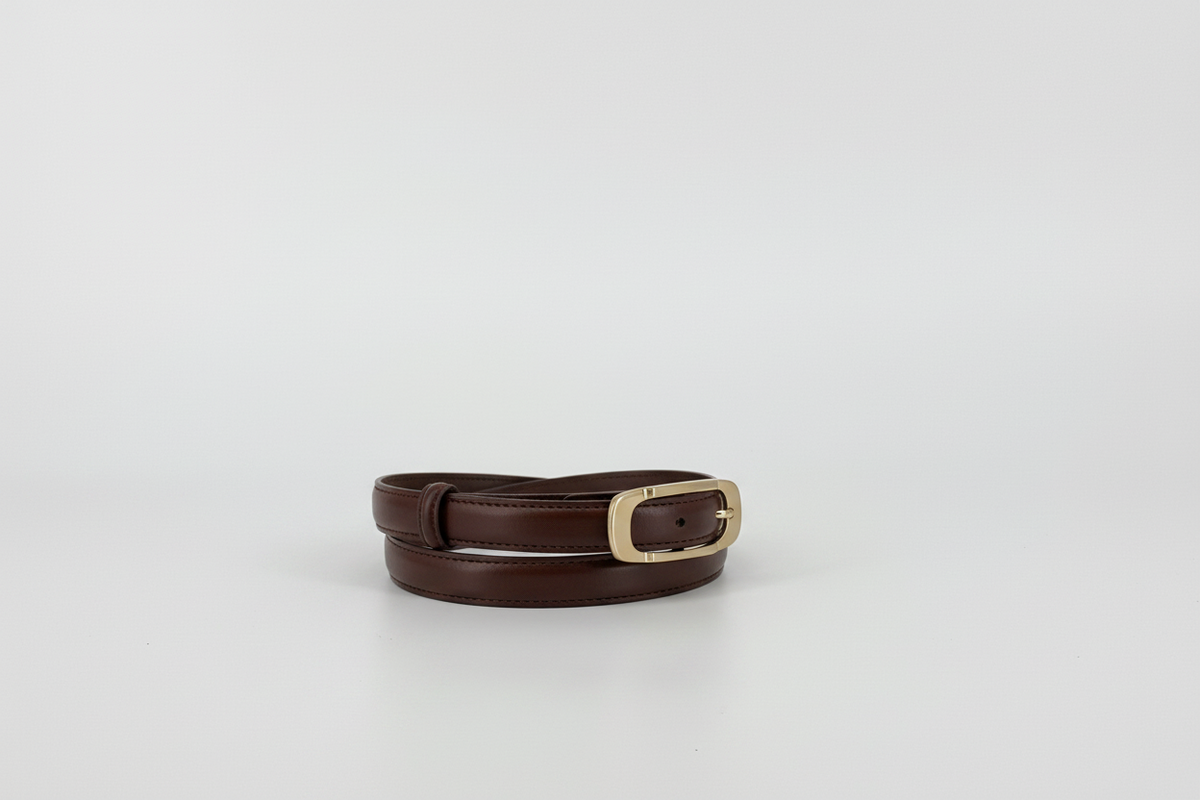 Cacao brown leather belt with a polished gold-tone metal buckle, showing the inner tan lining, set against a plain light gray background.