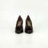 A pair of dark burgundy patent leather pumps with tassel details on the toes, shown from the front side against a plain white background.