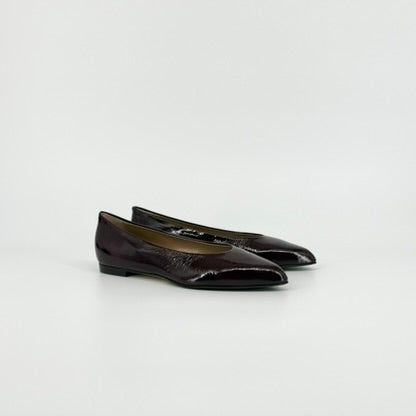 A pair of dark bordeaux patent leather ballet flats with a pointed toe, displayed on a clean light gray background.