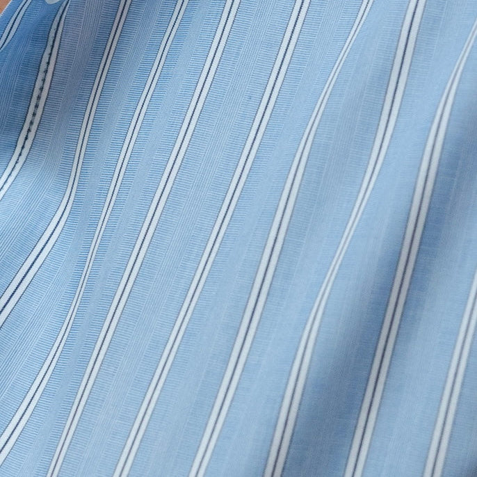Close-up of a blue and white striped fabric with a button visible.
