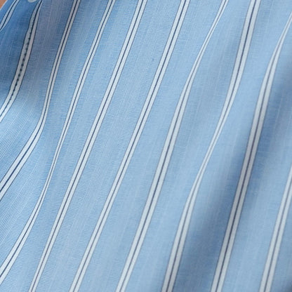 Close-up of a blue and white striped fabric with a button visible.
