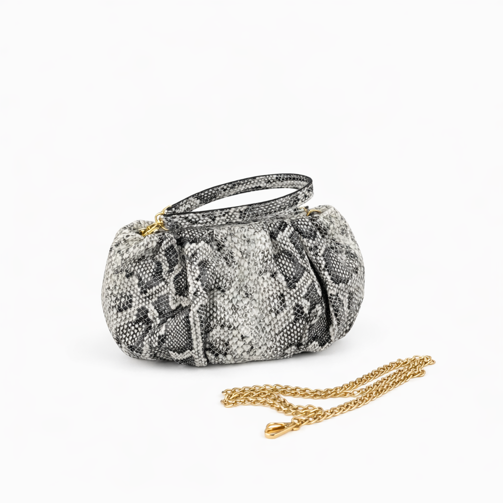 Faux Python Printed clutch with a gold chain and wrist strap on a white background