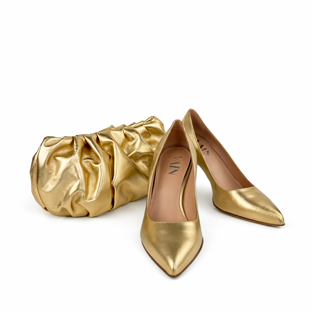 Gold high-heeled shoes and matching pouch on a white background