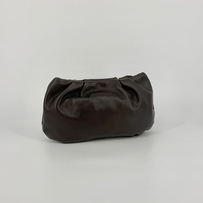 Large soft nappa leather clutch in dark brown with metallic strap on a white background