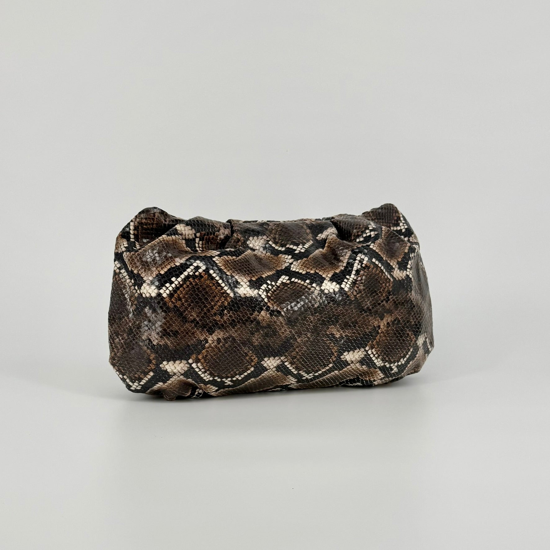 large clutch bag in a feminine folded shape in brown and black python printed leather on a white background