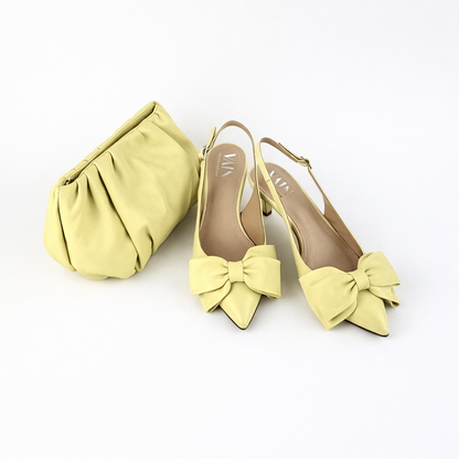 Lemon Meringue Yellow coloured shoes with bow details and a matching clutch on a white background