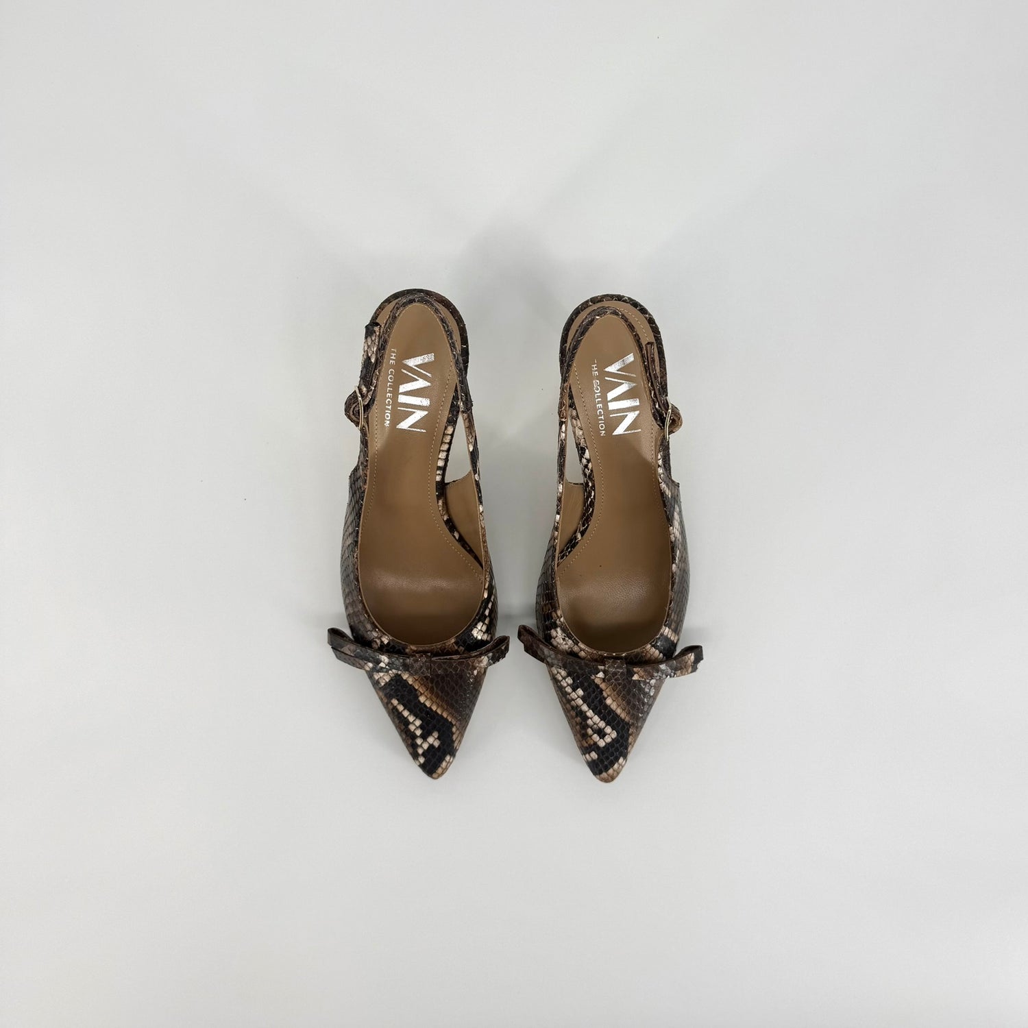 A pair of pointed-toe slingback pumps featuring a brown and black snakeskin pattern, displayed on a light gray background.