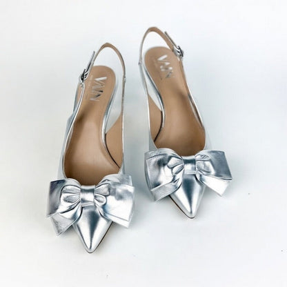 Silver low-heeled shoes with large bows on a white background