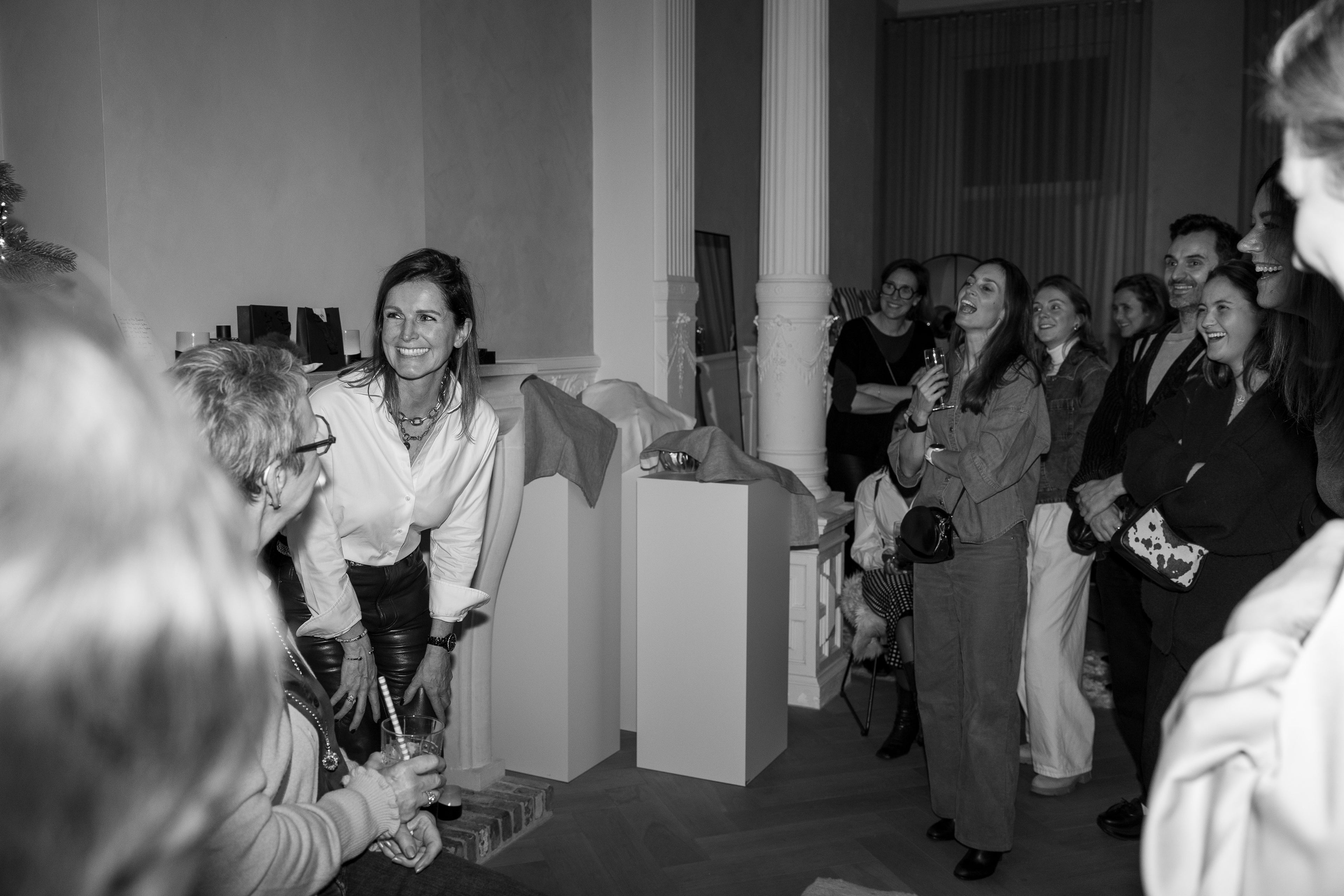 Woman speaking at a podium with an audience in a formal setting