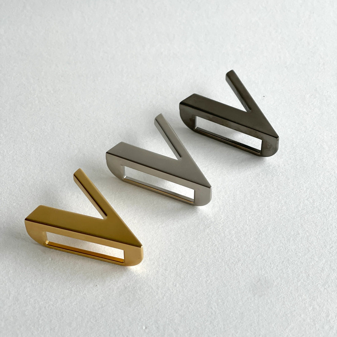 a gold brushed buckle a silver brushed buckle and a dark silver brushed buckle