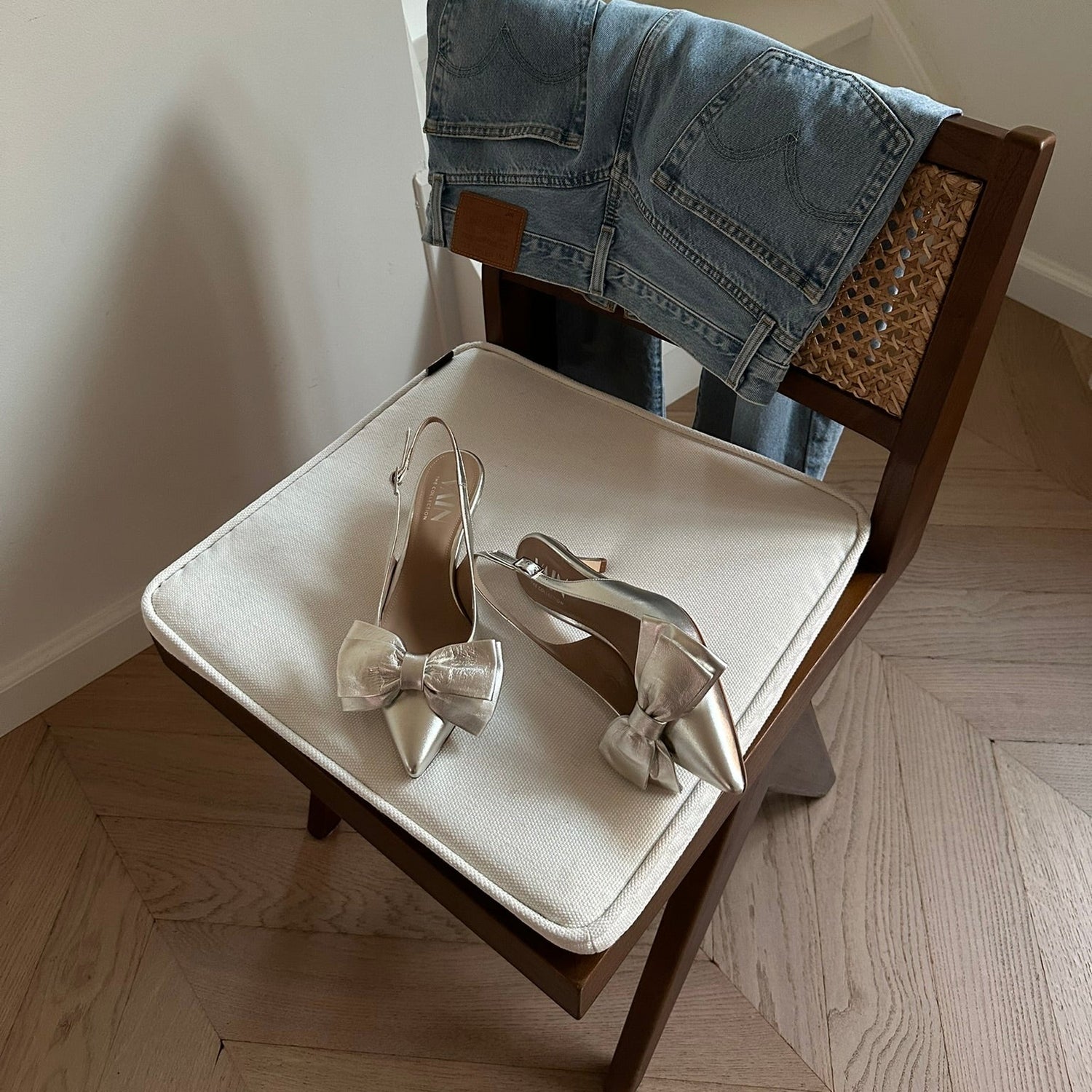 champagne kitten heels slingbacks on a chair with jeans hanging over the chair