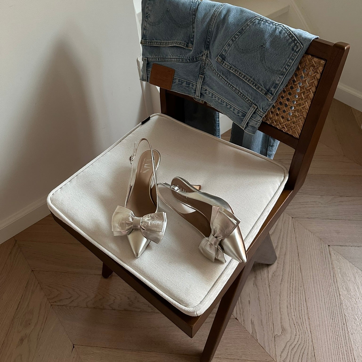 champagne kitten heels slingbacks on a chair with jeans hanging over the chair