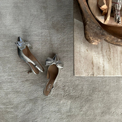 champagne kitten heels slingbacks on carpet next to decoration