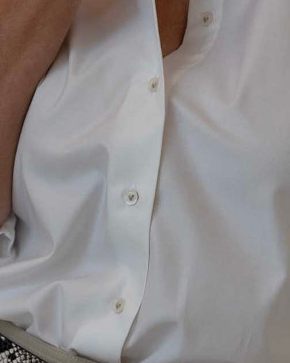 Close-up of a white shirt with buttons on a plain background