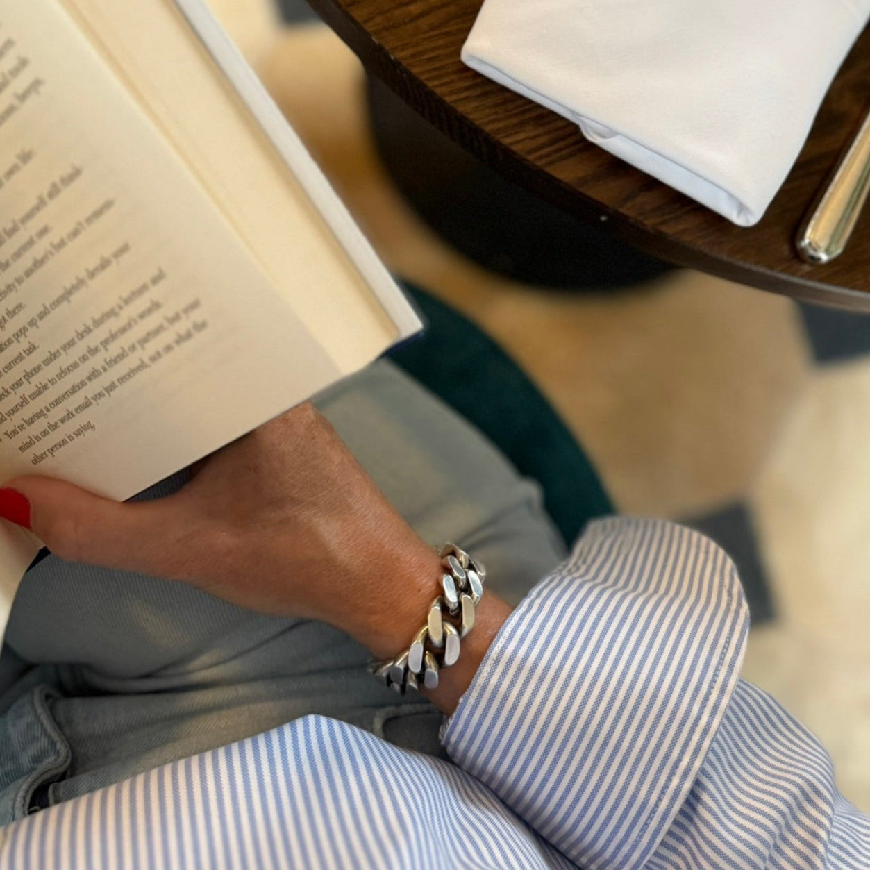 Person reading a book with a table setting in the background