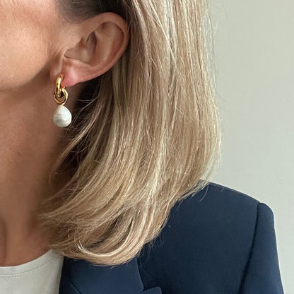 woman wearing gold earring with large pearl